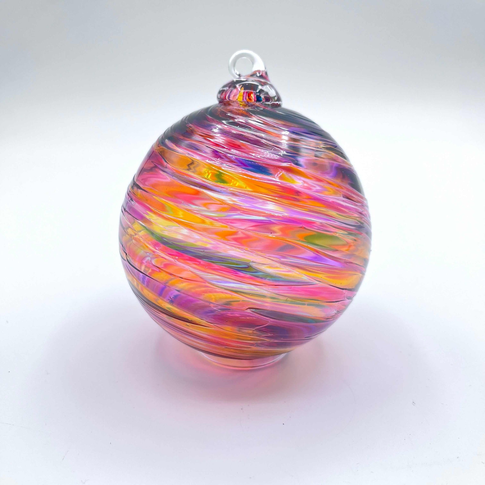 Hand blown Sunset Spiral Twist glass ornament with vibrant orange, pink, and purple swirls, 4x4 inches, perfect for holiday gifting.