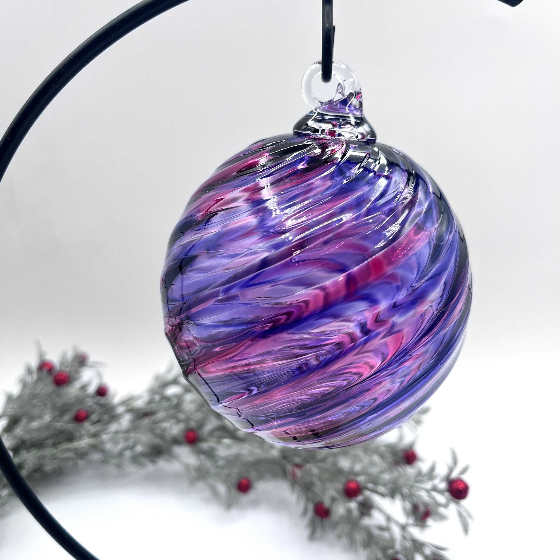 Purple Mix Spiral Twist hand blown glass ornament with swirled purple and pink hues hanging on black metal stand