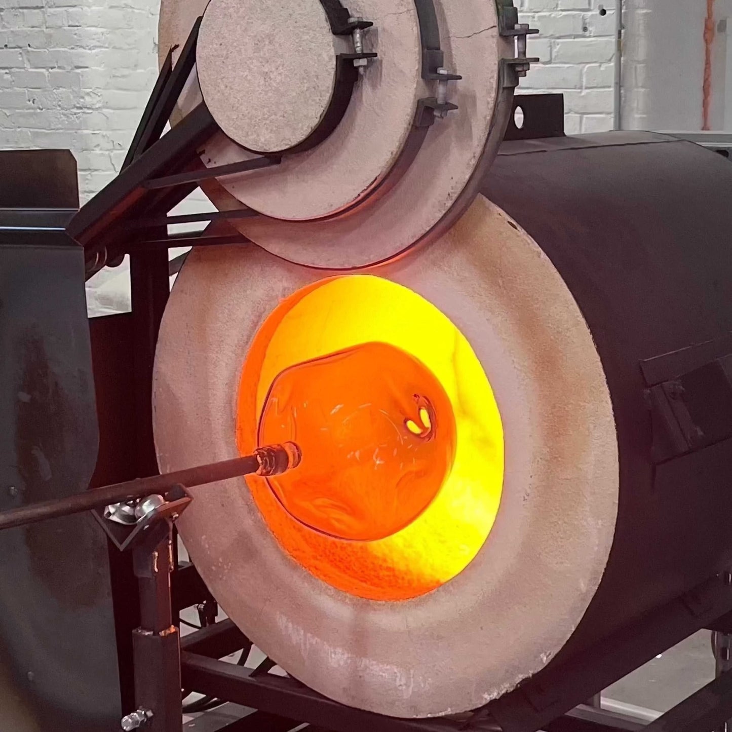 Glassblowing process shaping a stemless wine glass inside a hot furnace for Ladies Night Make Your Own event