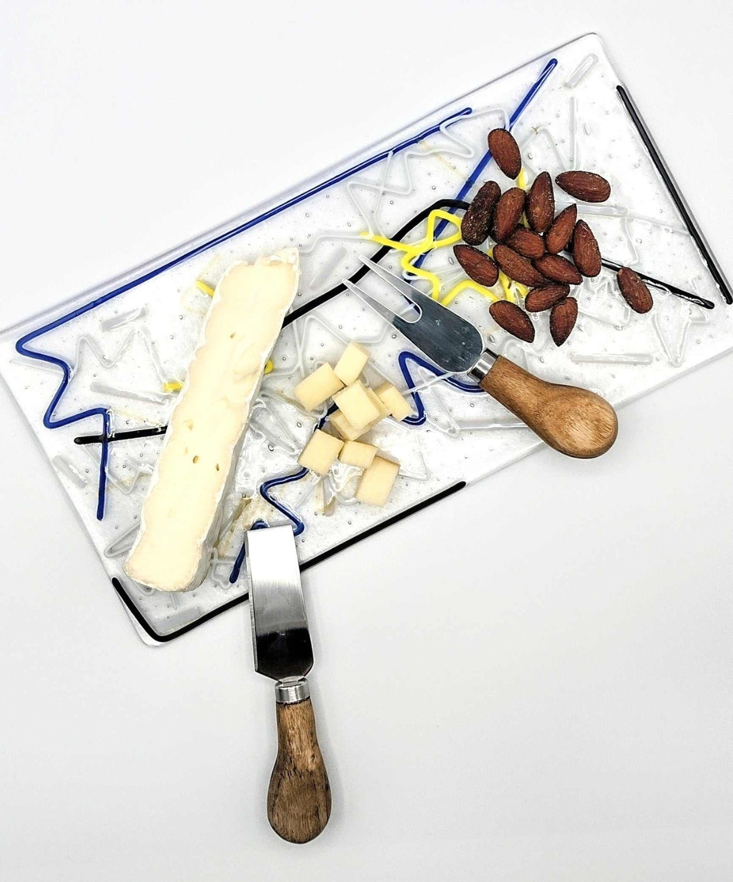 Choose Your Own Fusing Project fused glass cheeseboard with cheese, almonds, and spreader knives.