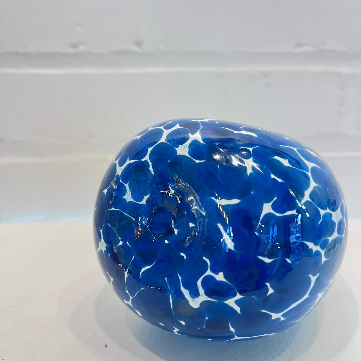 blue and white marbled glass soap dispenser with rounded shape