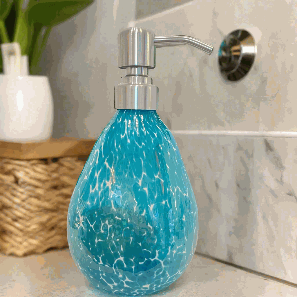 Hand blown glass teal speckled soap dispenser with silver pump on bathroom counter
