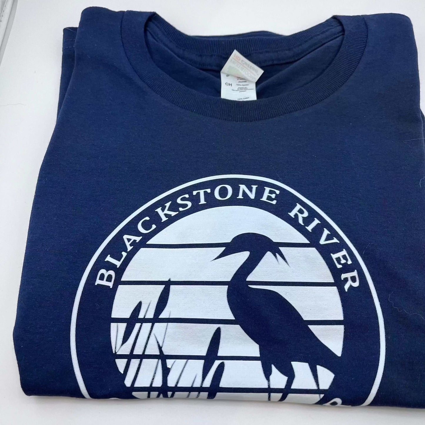 Folded navy blue BRGC Unisex T Shirt with a white circular Blackstone River heron logo on the front.