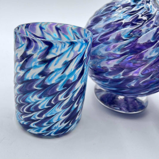 Handmade marbled glass vanity set in hyacinth and aqua tones featuring a soap dispenser, matching bowl, and coordinating glass.