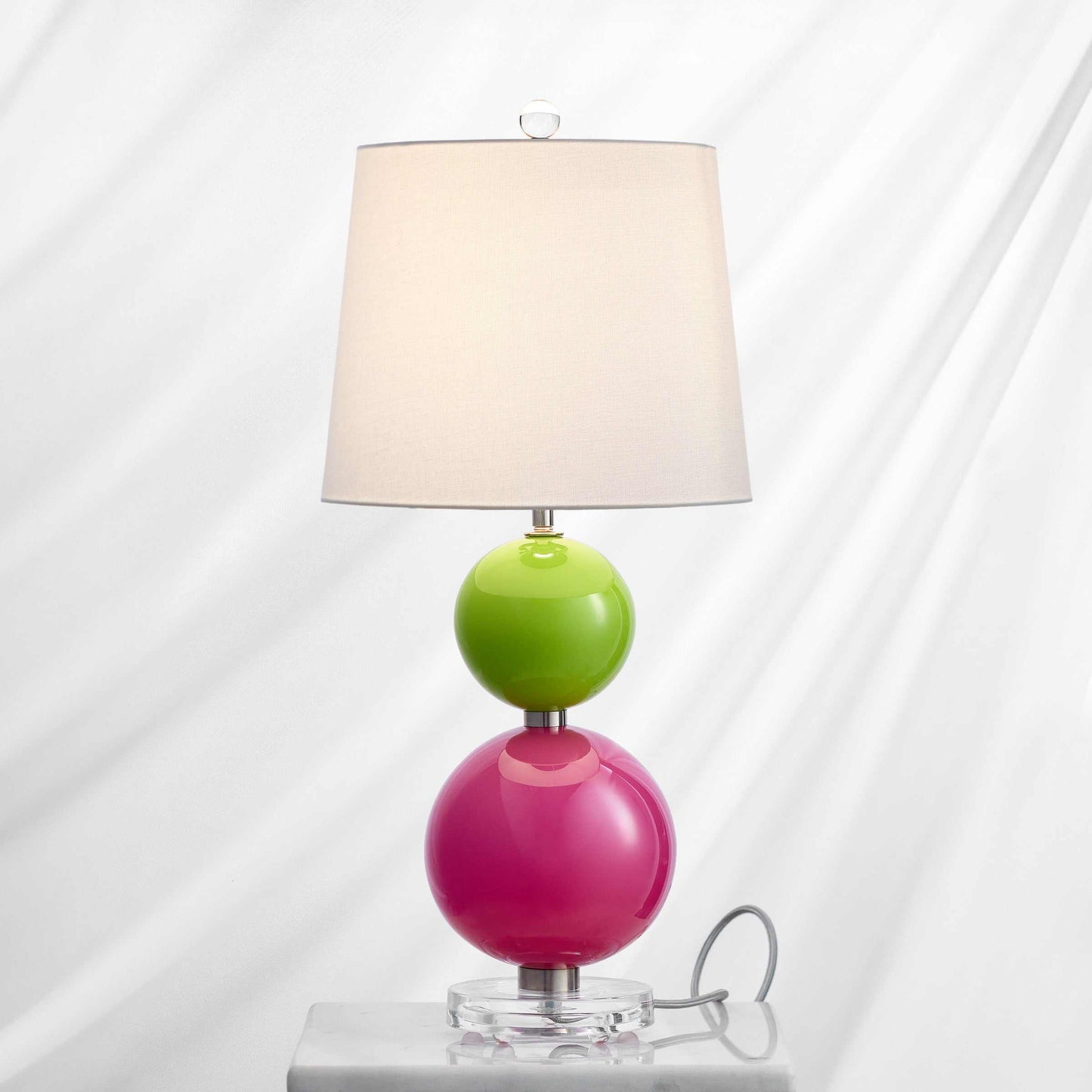 Betty Bold Table Lamp with electric pink and melon green hand-blown glass globes, off-white fabric shade, and clear acrylic base.