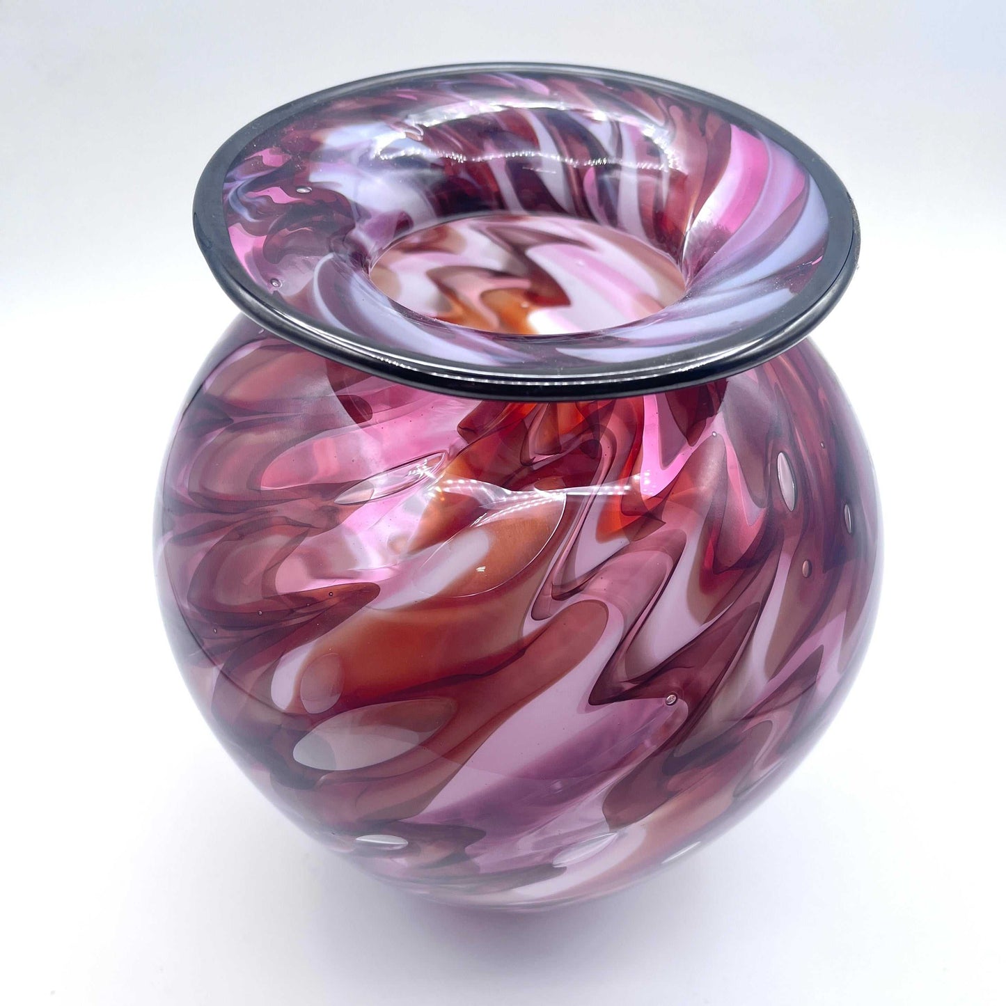 Hand blown lava vase with swirling red and purple lava patterns and flared rim