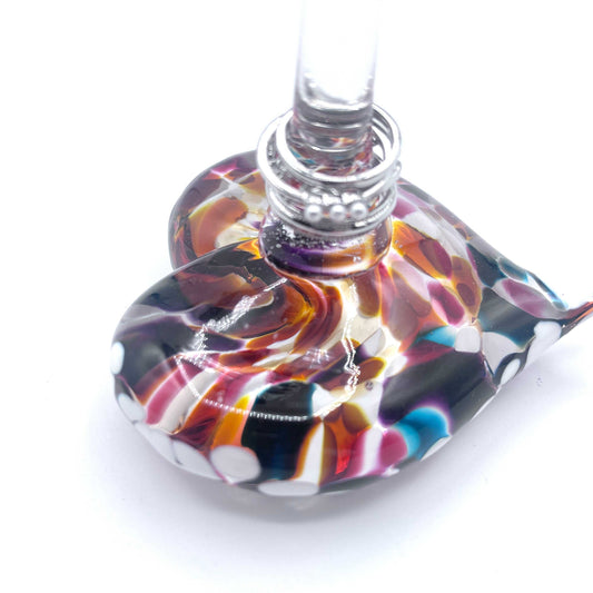 Handblown multicolored glass heart ring stand with silver rings displayed on central post