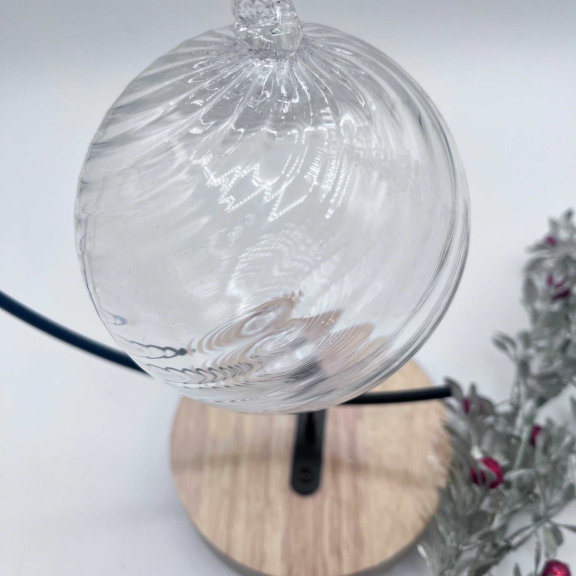 Clear spiral twist blown glass ornament hanging on a stand