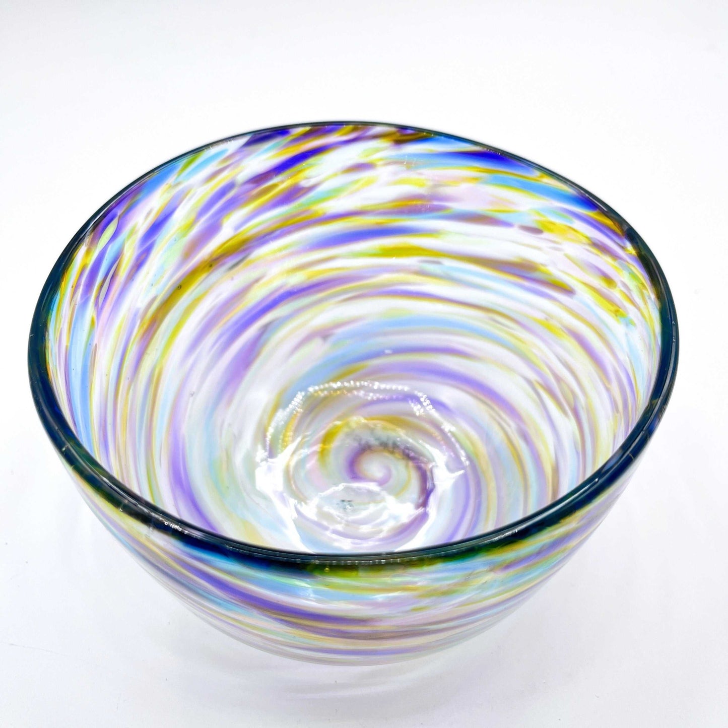 Colorful handblown glass bowl with swirling purple, blue, and yellow patterns made from hot glass