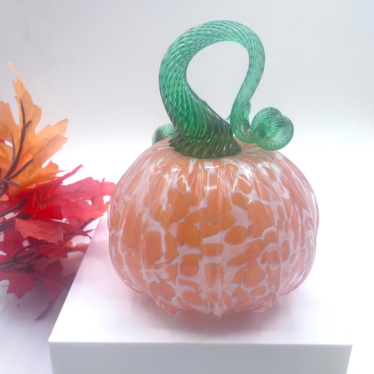 Hand-blown art glass pumpkin in orange creamsicle color with green twisted stem, autumn decor collectible
