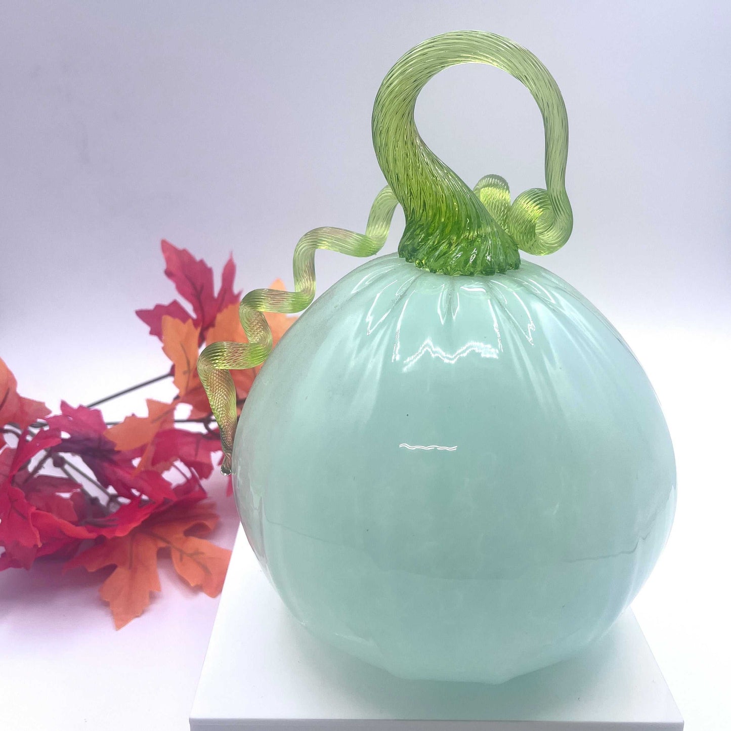 Large hand-blown art glass pumpkin in celedon color with lime stem and curly vine detail