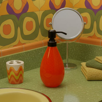 Orange bottle with bronze pump on a white platform against a light gray background