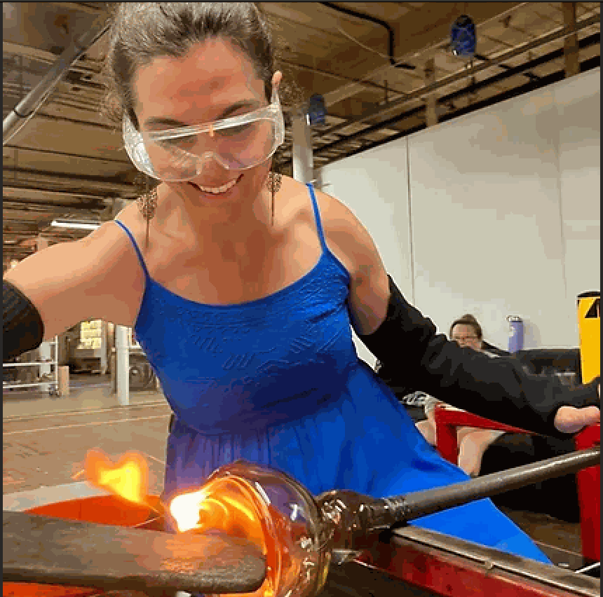 Woman shaping molten glass during a 3 hr private glassblowing workshop session