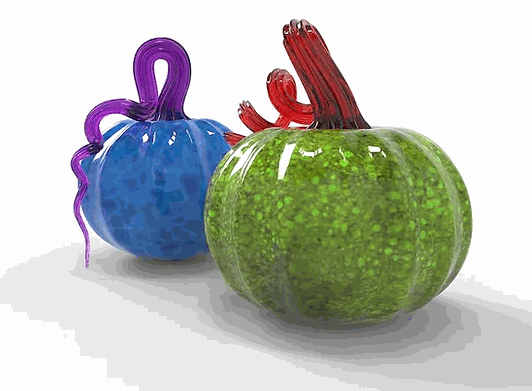 Two colorful handmade glass pumpkins, one green with a red stem and one blue with a purple stem, showcasing Make Your Own Pumpkin glass art project.