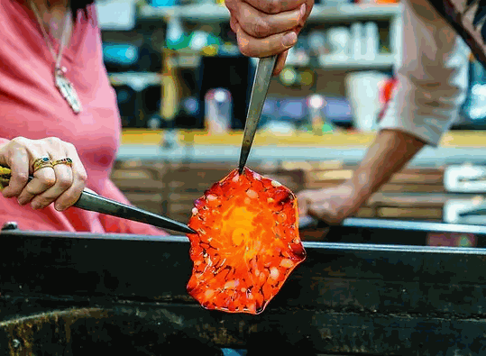 Close-up of hands shaping molten glass during 6 Week Intermediate Glassblowing Course