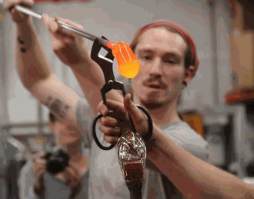 Man shaping molten glass with tools during 6 Week Intermediate Glassblowing Course