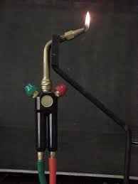Hot Torch with oxygen and propane hoses producing a flame on black background