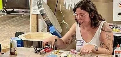 Woman creating glass art in a private group flameworking and flat glass studio session