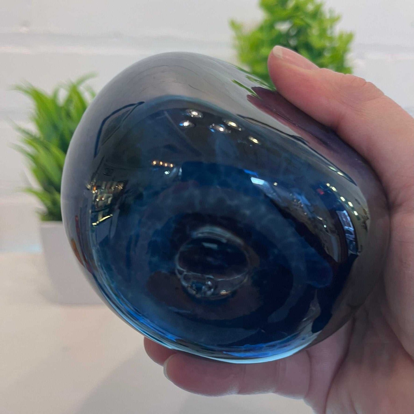 Hand blown blue glass soap dispenser bottle held in hand, 12-ounce capacity, smooth rounded design