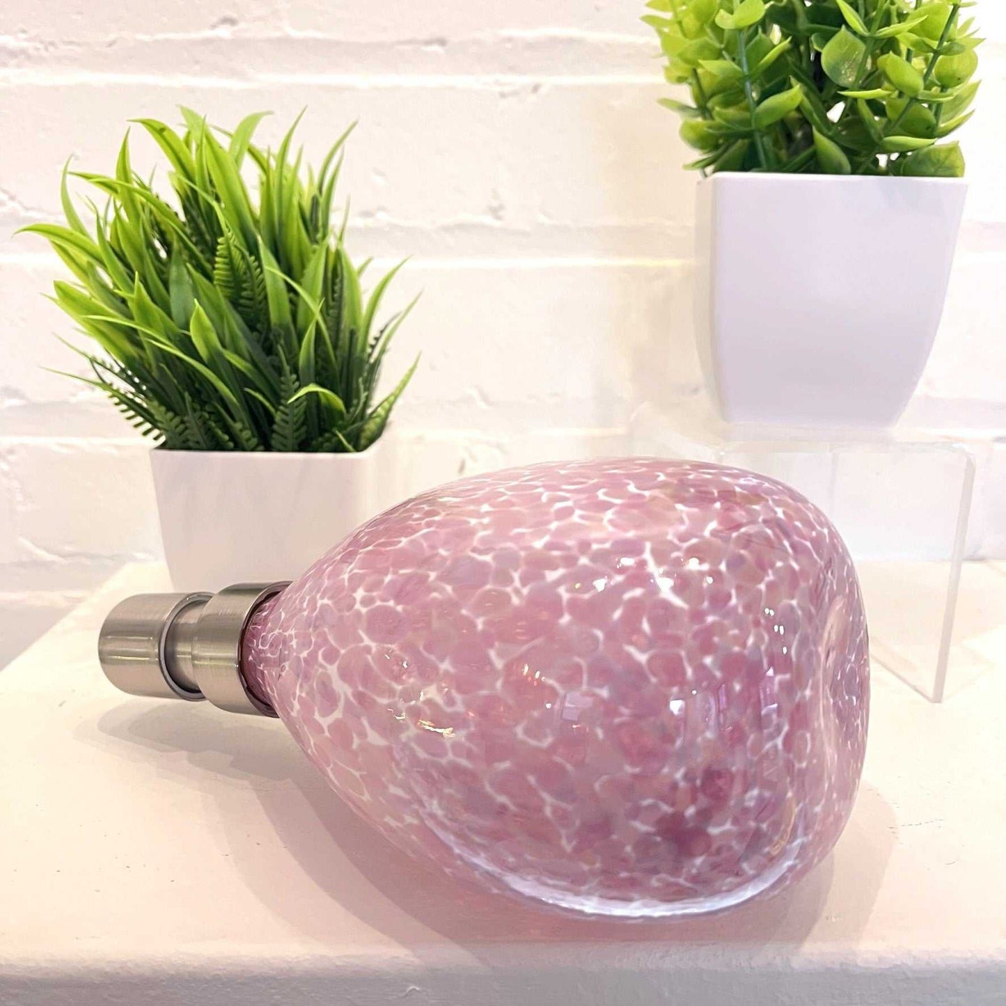 pink hand blown glass soap dispenser with silver pump and speckled design