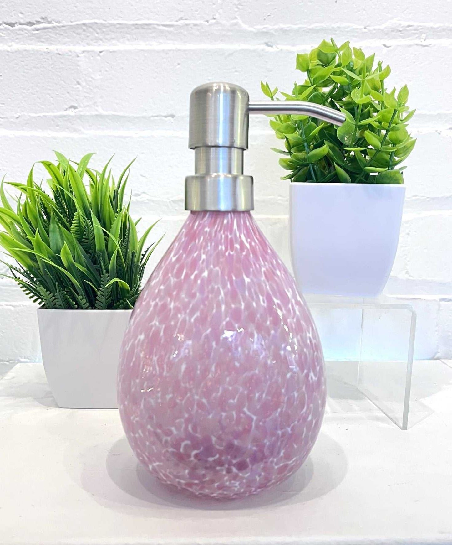 Pink hand blown glass soap dispenser with stainless steel pump and speckled design, 12-ounce capacity.