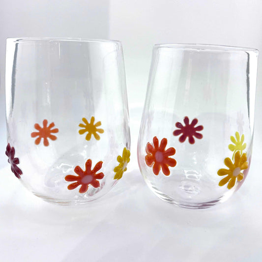 Hand blown Flower Power stemless wine glasses with colorful retro flower designs, 12 oz capacity, dishwasher safe.