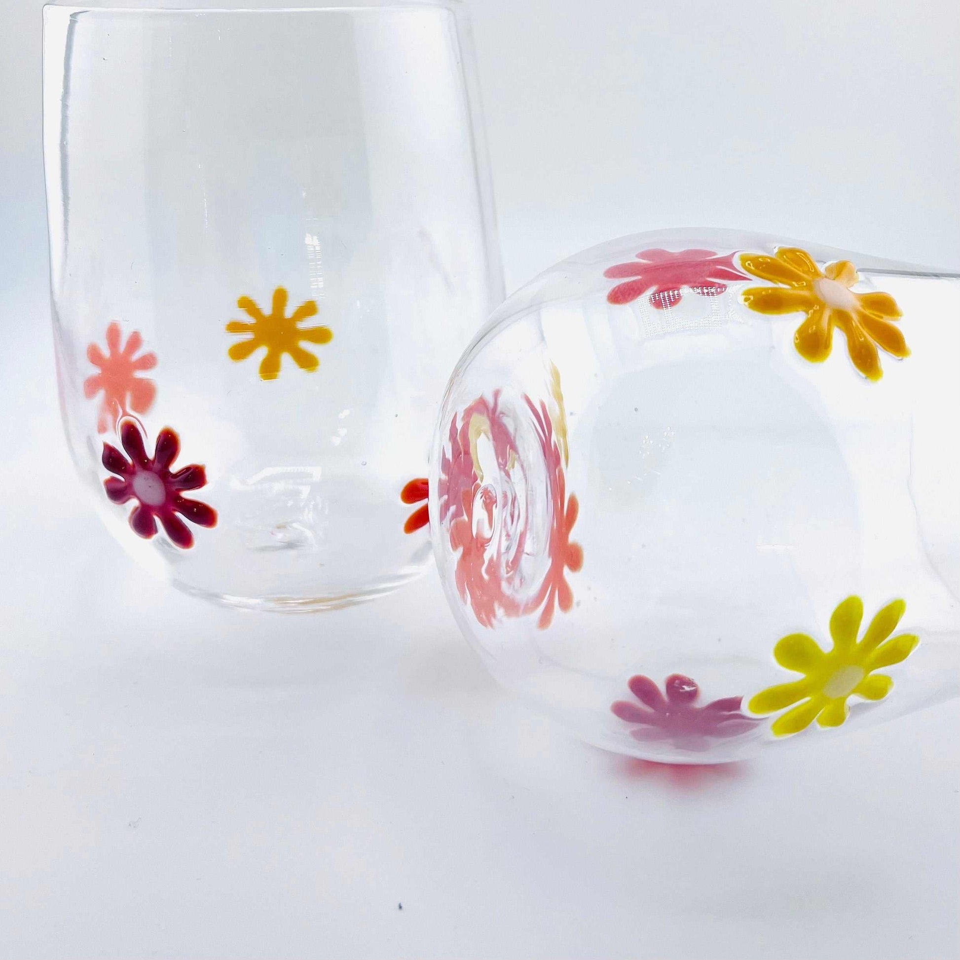 Flower Power Stemless Wine Glasses with colorful hand-blown glass flowers, 12 oz capacity, dishwasher safe.