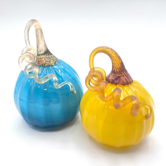 Set of two hand blown glass pumpkins in blue and yellow with curly stems, handmade by Blackstone River Glass Center