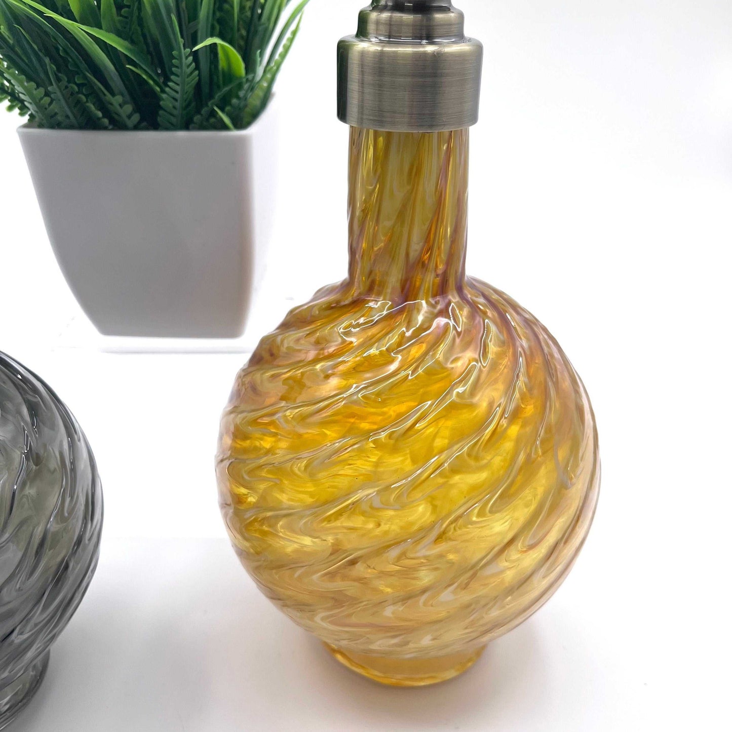 Handblown marbled glass soap dispenser in gold with textured swirl design and metal pump top.