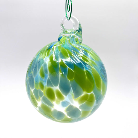 Green speckled hand blown glass ornament with blue and green swirls hanging loop
