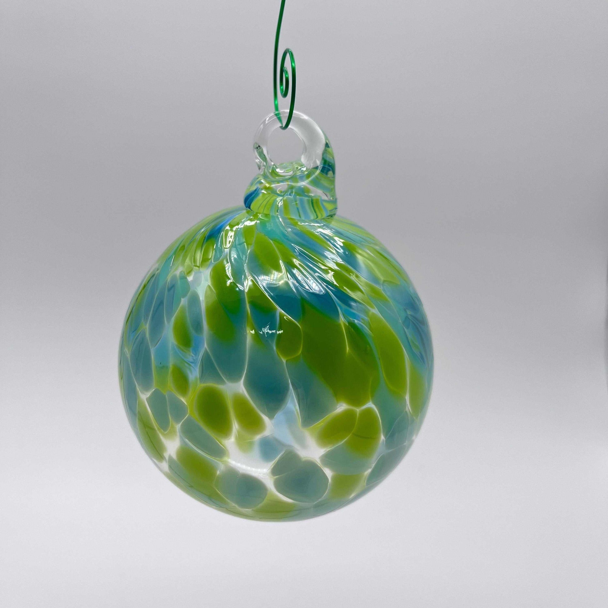 Green speckled hand blown glass ornament hanging with swirled blue and green patterns, 4x4 inches, perfect for gifting and year-round decoration