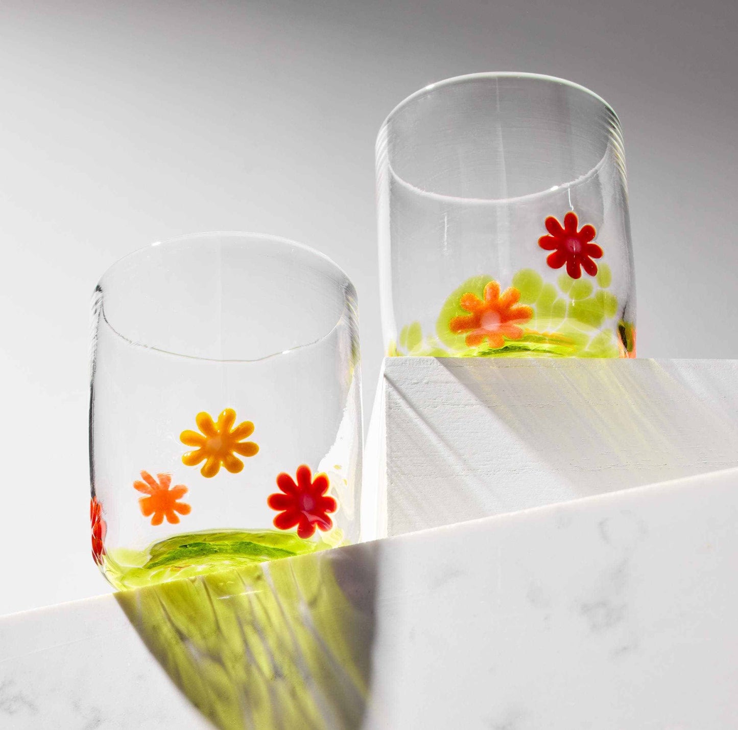 Set of hand blown whiskey glasses with colorful flower designs, artisan-crafted with vibrant glass flowers, dishwasher safe, 12 oz capacity.