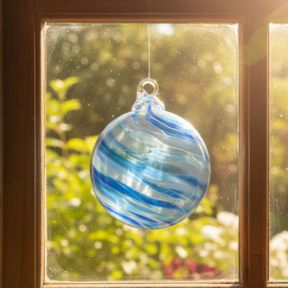Blue and white swirled glass ornament on a white background