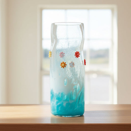 Hand blown flower art glass vase with colorful glass flowers and blue base on marble slab