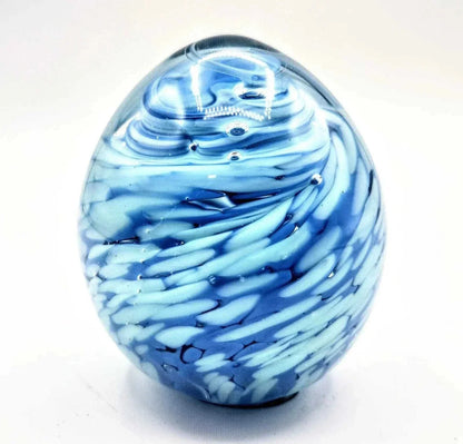 Blue and white swirled glass paperweight with smooth, rounded shape and artistic patterns