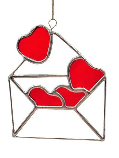 Stained glass window hanging with red hearts in an envelope design on a white background