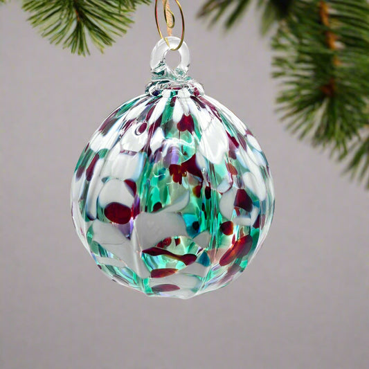 Holiday hand blown glass ornament with red, green, and white speckled design, 4x4 inches.