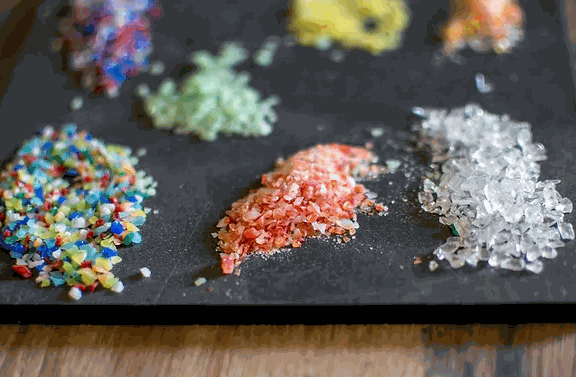 Colorful glass frits laid out for making your own ornament glass blowing class craft materials