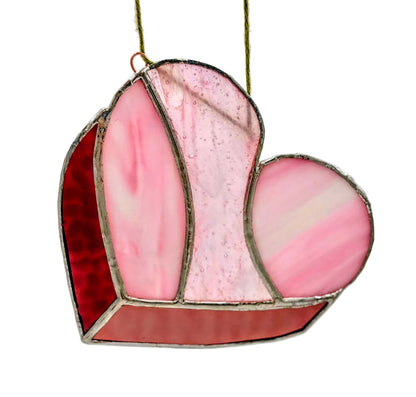 Heart-shaped stained glass panel with pink and red colors on a white background