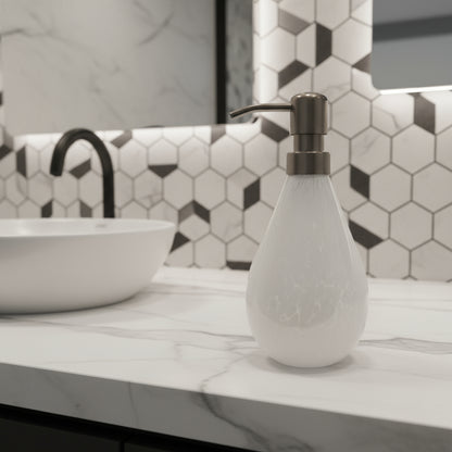 White soap dispenser with a metallic pump on a white platform against a light gray background