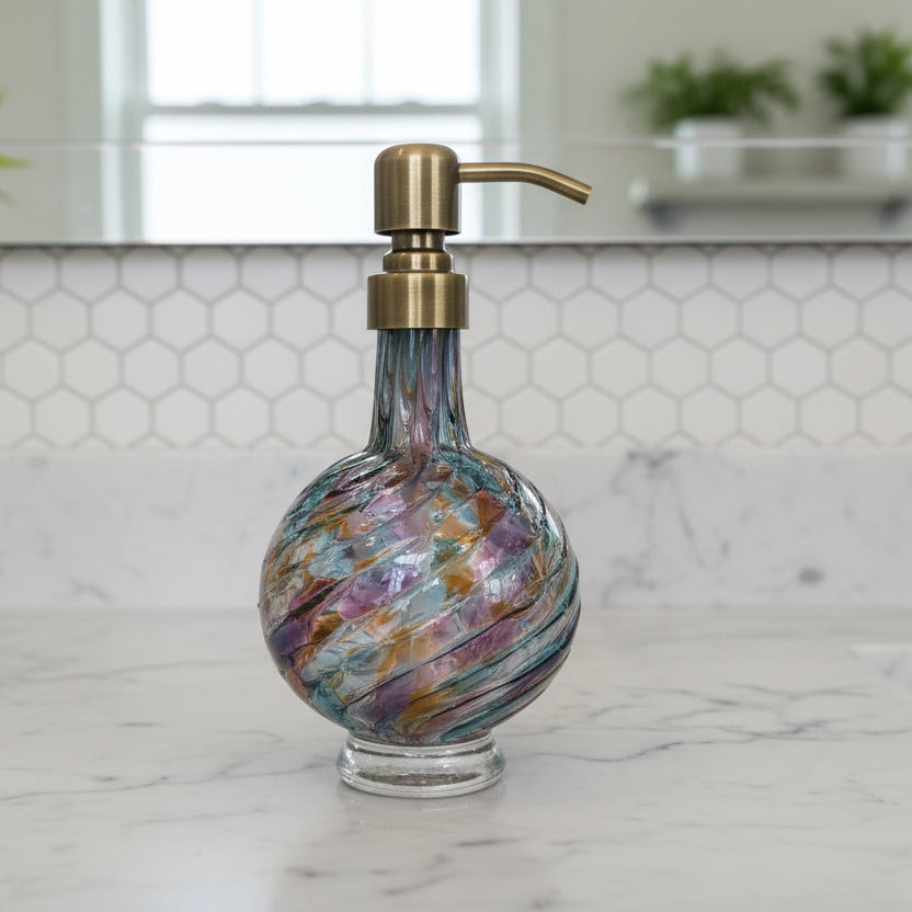 Multicolored glass soap dispenser with brass pump on a white background