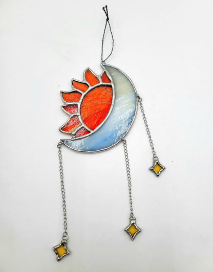 Stained glass sun and moon design with chains and stars on a white background