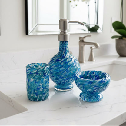 Marbled glass vanity set in ocean blue with hand-blown soap dispenser, matching bowl, and coordinating glass