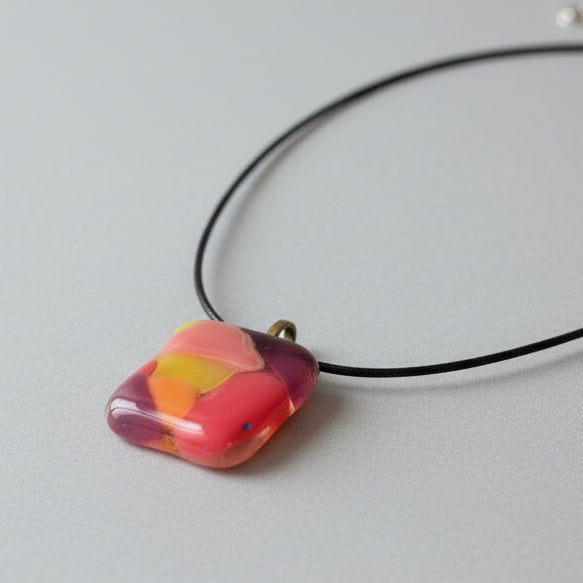 Colorful fused glass pendant necklace from Choose Your Own Fusing Project with abstract red, yellow, and pink design