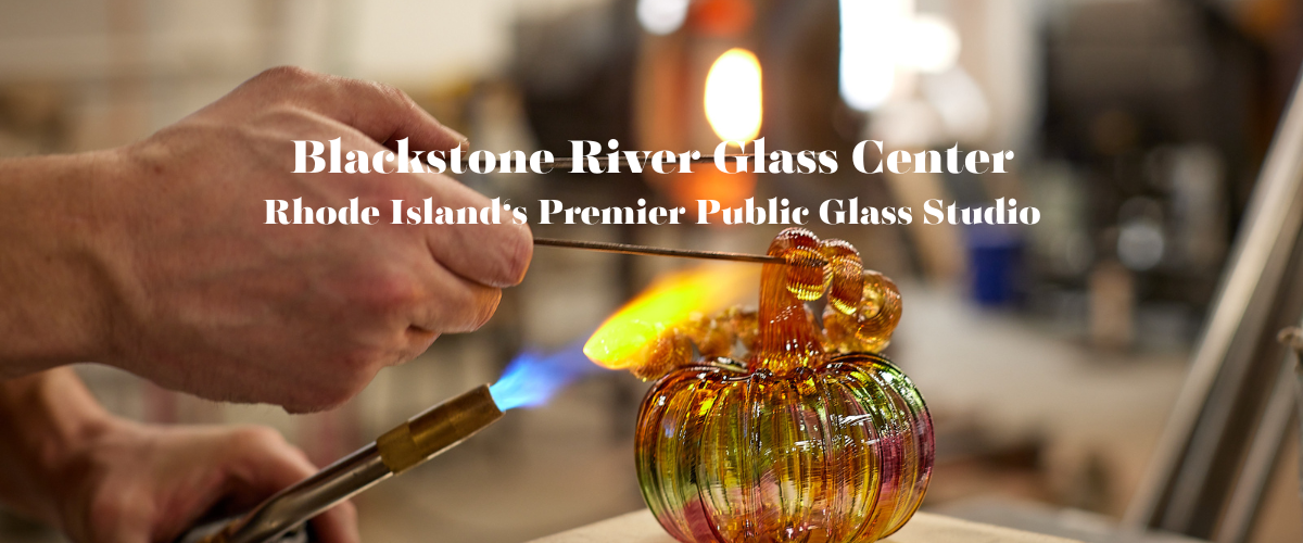 Person working with glass at Blackstone River Glass Center, a public glass studio.