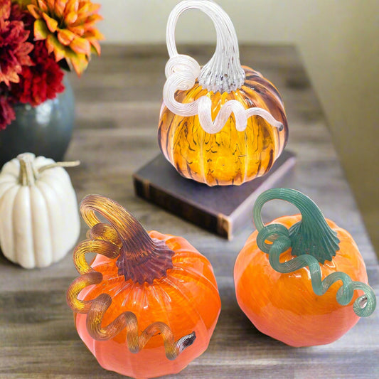 Set of three hand blown glass pumpkins with curly stems in orange and amber tones, each signed and dated, handcrafted by Blackstone River Glass Center.